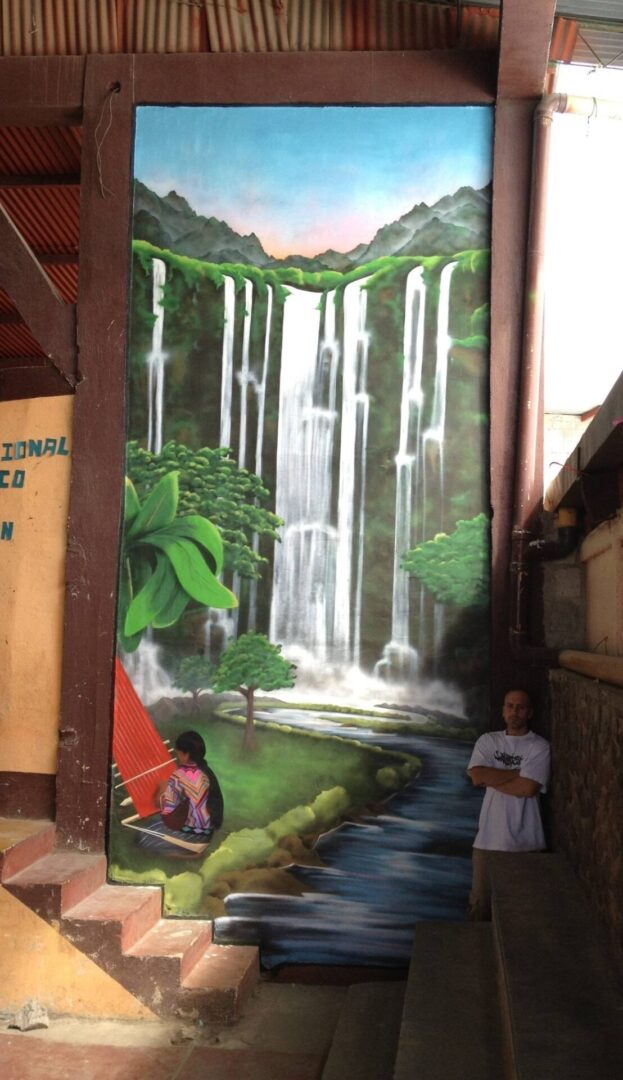 A mural of a waterfall and people in front.