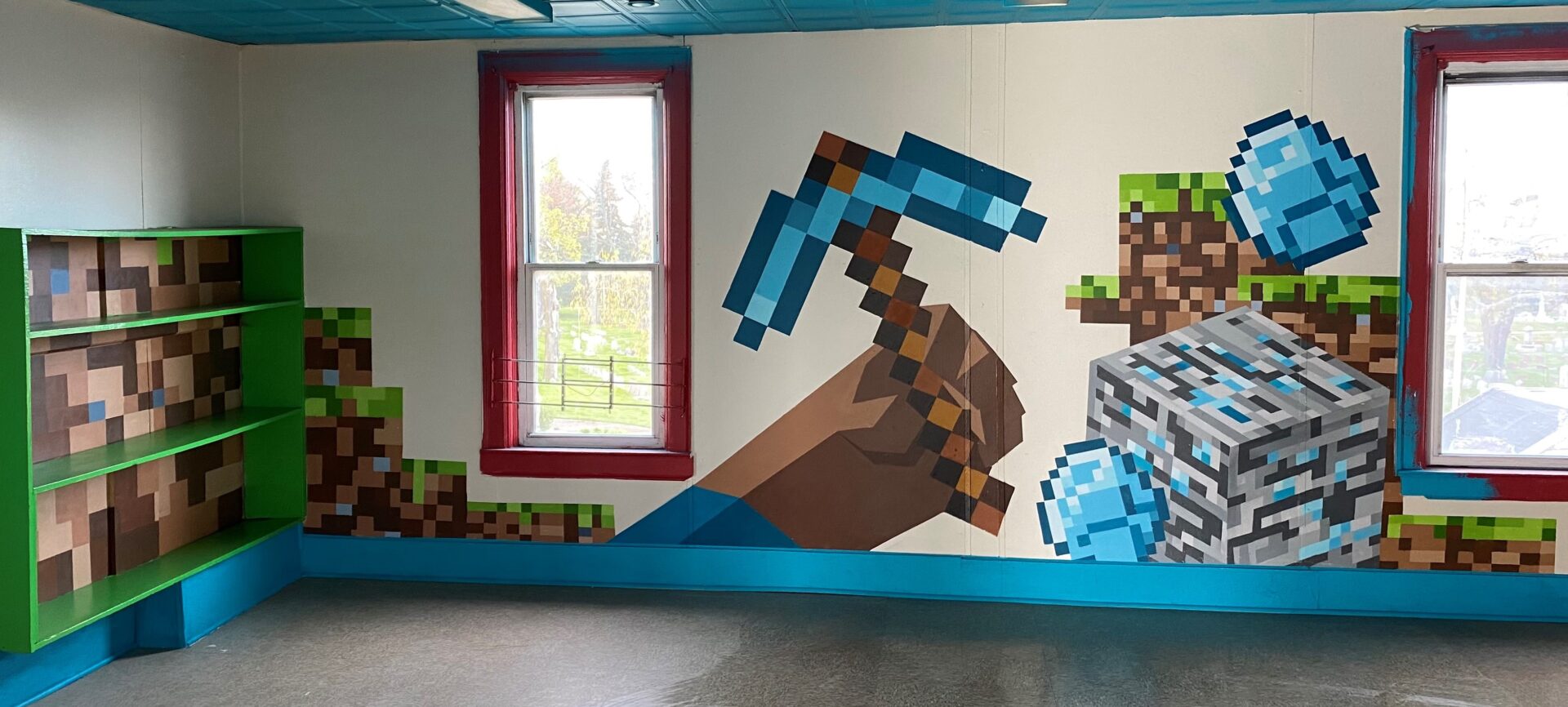 A room with a mural of a hand holding an iron pickaxe.