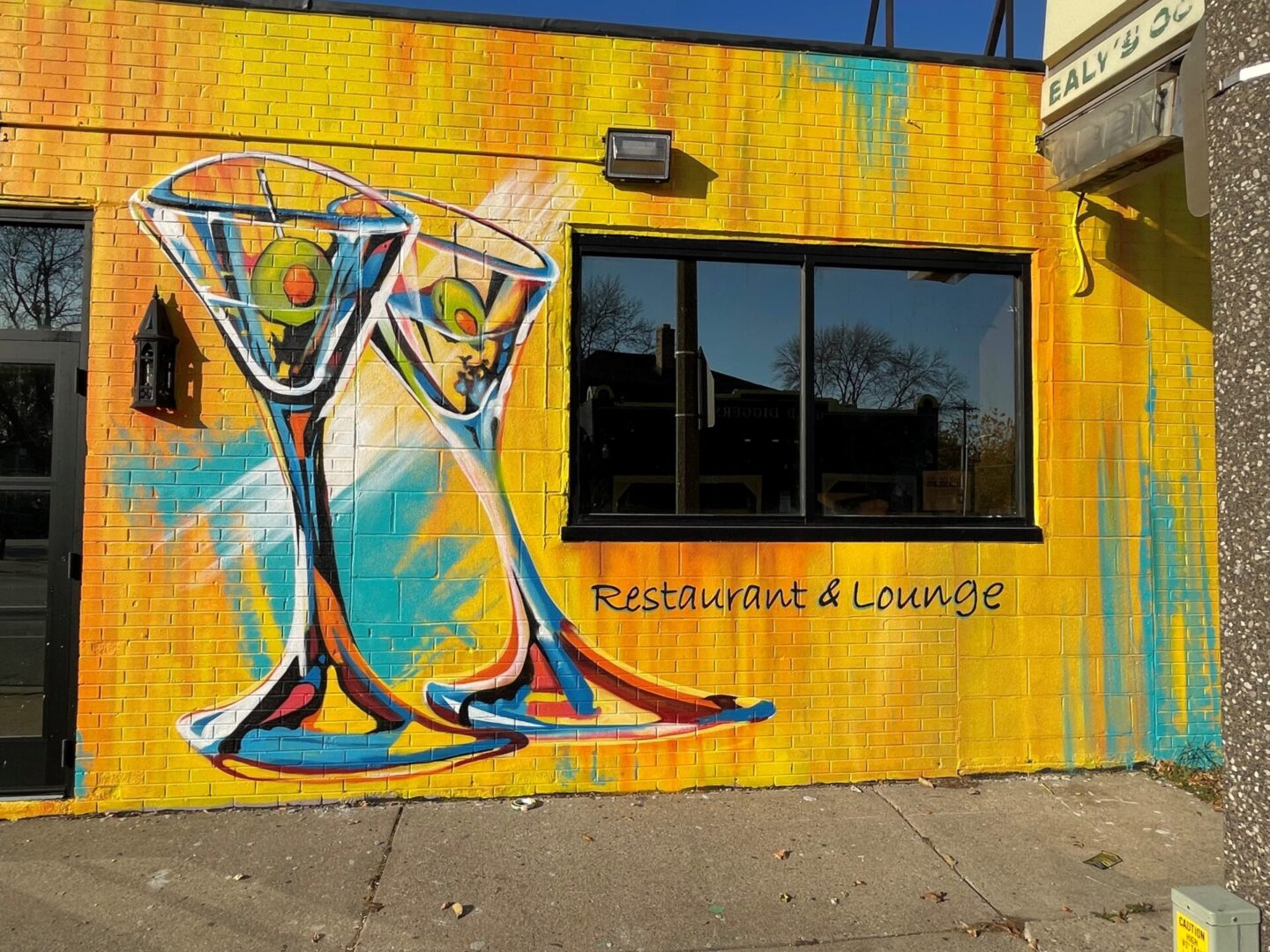 A mural of two glasses on the side of a building.