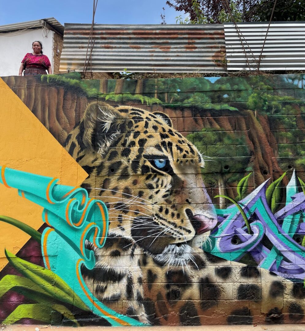 A man standing in front of a wall with graffiti.