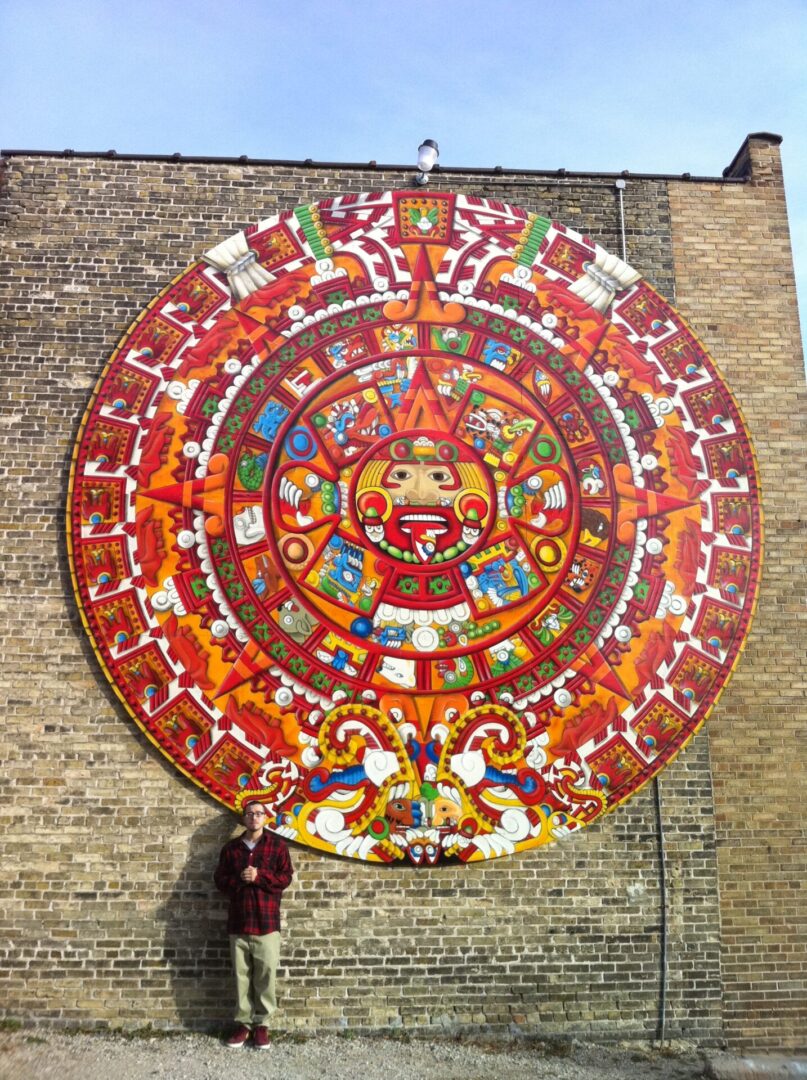 A large colorful mural of an aztec calendar.