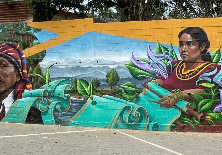 A mural of a woman with a surfboard in the background.